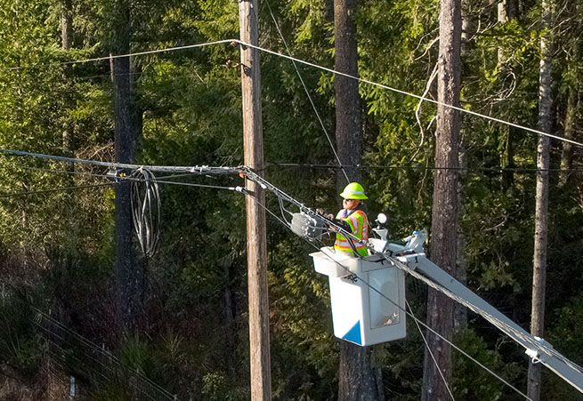 Man expanding wires on pole